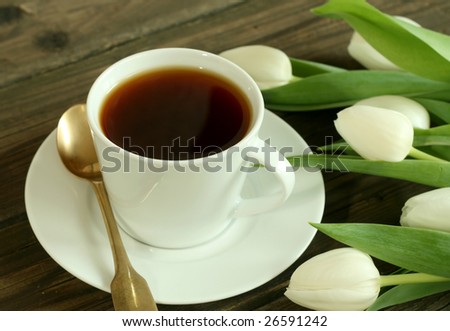 Cup of tea and white tulips