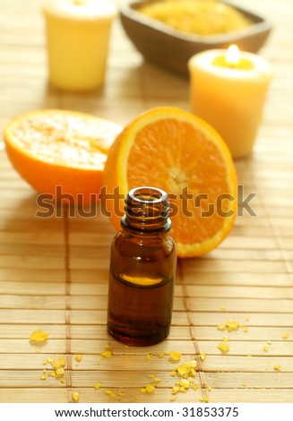 bottle of essence oil, fresh oranges, bath salt and candles.