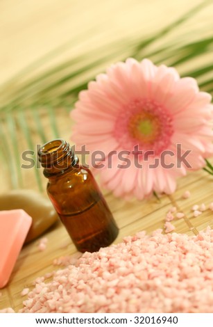 bottle of essence oil, pink bath salt and gerber