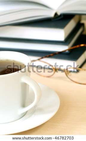 Cup of tea, books and eyeglasses
