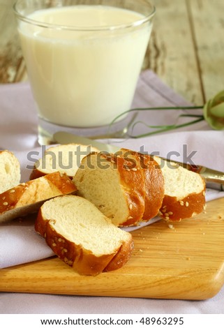 white bread with sesame and glass of milk