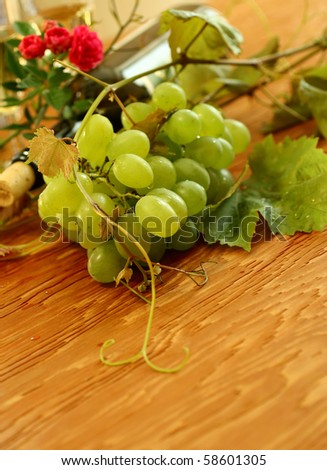 fresh grapes, vine and vine bottle on wooden background