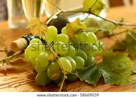fresh grapes, vine and vine bottle on wooden, holiday background