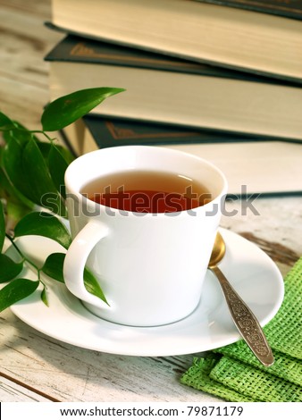 cup of tea and books on wooden