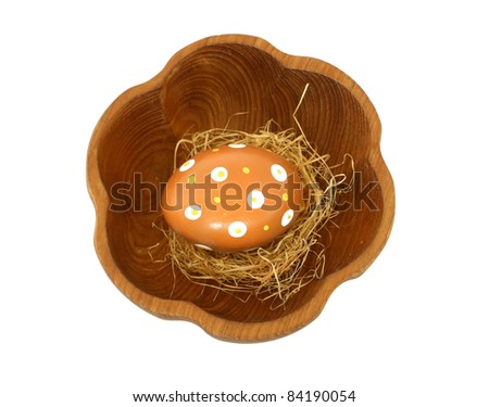 Easter egg with ornament in wooden bowl isolated on white background