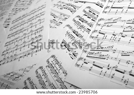 Studio shot of scattered music sheets, shallow depth of field.