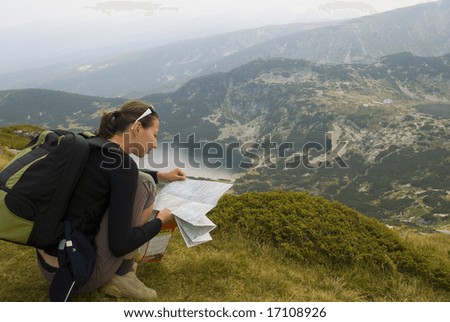Resting mountaineer is reading a map. The picture was taken on the Seven Rila lakes in the Rila mountain, Bulgaria.