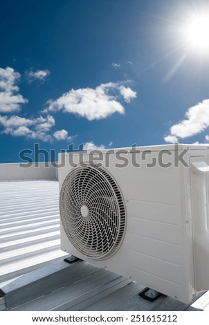 White air conditioning unit on a metal industrial roof.