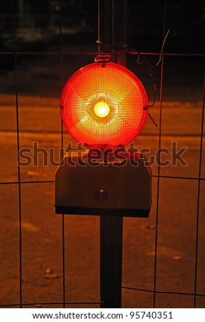 Warning light  Photo of a burning warning light in front of metal grid fence