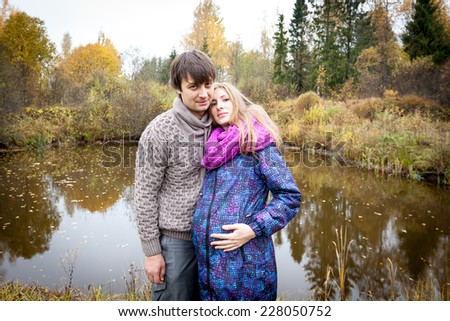 Couple of young future parents during pregnancy on the lake