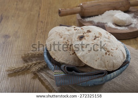 indian bread in a traditional basket with raw material in the background
