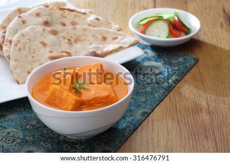 shahi paneer in a bowl along with indian bread in background