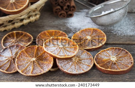Dried oranges with powdered sugar on a wooden table. Christmas composition