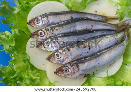 salted fish with spices on lettuce leaves