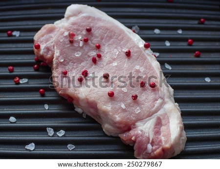 raw pork chop with pepper and salt