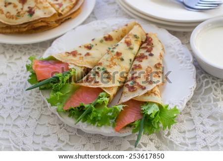 Thin rolled pancakes, crepes with salmon, . Traditional Russian dish.