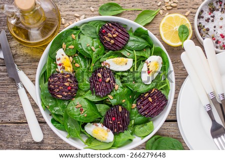 Fresh spinach salad, eggs and roasted beets with flax and sunflower seeds
