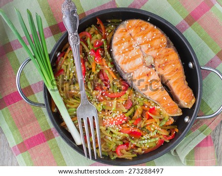Salmon steak with vegetables in pan portion