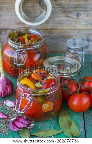 Pickles. Canned tomatoes. tomatoes in glass jar on wooden table. Fresh tomatoes