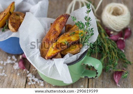 Potato wedges with thyme and garlic. The rustic style. Selective focus