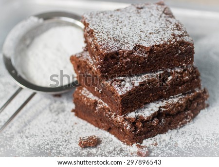 Brownie. Chocolate cakes with powdered sugar  on a metal baking sheet.  American dish. Selective focus