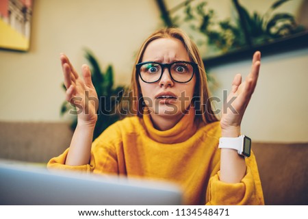Portrait of shocked disappointed woman feeling stress of problems with software development, embarrassed female it professional in eyewear looking at camera confused from received freelance task