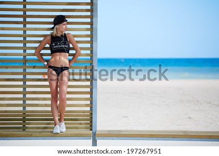 Female jogger with a beautiful figure resting on the sea background