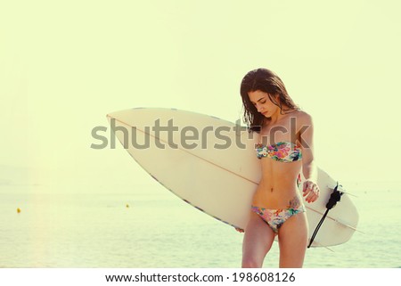Stand up paddle board yoga performed by beautiful girl on the bright sunset background, yoga training on the beach