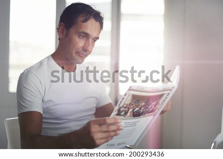 Attractive man in a white shirt reads journal waiting in the cabinet clinic