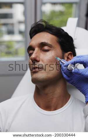Attractive man in beauty clinic getting injection to remove the wrinkles in professional aesthetic clinic