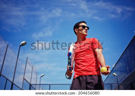 Athletic sportsman ready to feed ball in paddle game on beautiful blue sky background, paddle game outside, healthy lifestyle concept