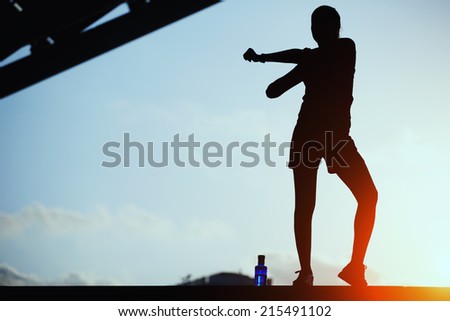 Silhouette of woman doing sports outdoors, beautiful female jogger doing workout during the evening training outdoors, attractive female runner stretching before her workout, woman fitness silhouette
