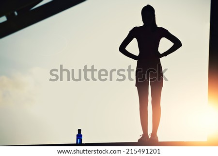 Attractive sporty women taking break after intensive evening run, woman fitness silhouette, fitness sport training in sunny sunshine, silhouette of female runner on beautiful sunset sky background