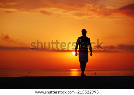 Silhouette of male runner with muscular body on colorful sunrise background, athletic jogger with beautiful figure at morning run outdoors, fitness and healthy lifestyle concept