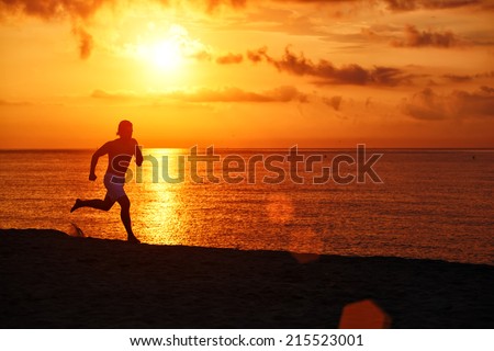 Silhouette of athletic runner jogging on the beach against orange sunrise, athlete man running in action on the beach,beautiful runner silhouette in action, fitness and healthy lifestyle concept