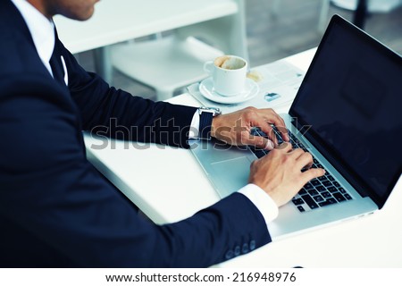 Male hands typing on laptop computer keyboard, businessman seated in cafe working with computer, businesspeople using modern devises, crop of rich businessman in suit working with laptop computer