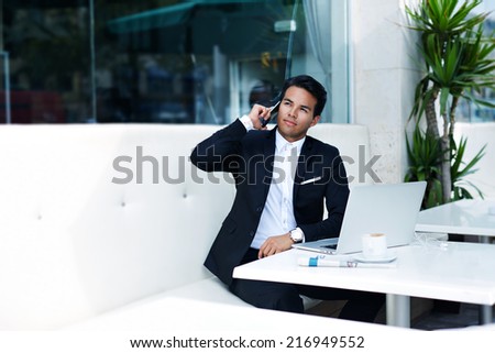 Businessman answering the phone with a smile, receiving good news, asian businessman having a phone talk, attractive rich man using mobile phone, emotions talking on the mobile smart phone