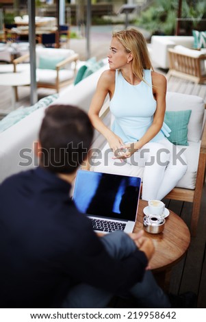 Business team of two success people sitting outdoors in lounge terrace and planning work, businessman and businesswoman meeting in modern place outdoors, business partners having meeting outdoors