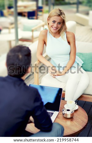 Portrait of a successful business woman smiling,business meeting of two success people sitting outdoors in lounge terrace and planning the work, blonde hair female executive at the conference outdoors