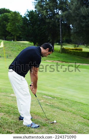 Professional golf player ready to hit the ball, successful attractive man playing golf on holidays