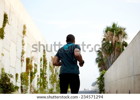 Muscular build athletic runner jogging fast outdoors