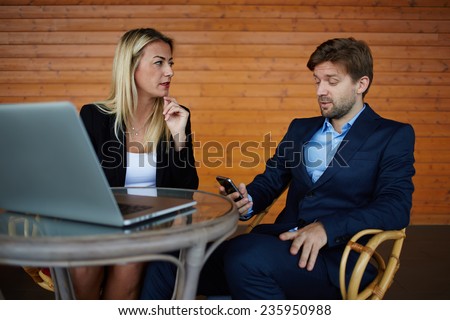 Group of successful business people having meeting together, two colleagues working together outside the office, young man and woman sitting with laptop computer and have a discussion, success concept
