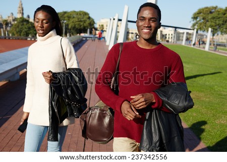 Friends having a great time together, two college friends laughing having good time, african couple smiling each to other at beautiful day two students smiling at college campus, happy people laughing