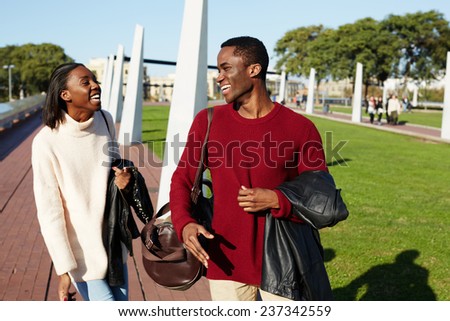 College friends laughing having good time, african couple smiling each to other at beautiful day two students smiling at college campus, happy people laughing, friends having a great time together