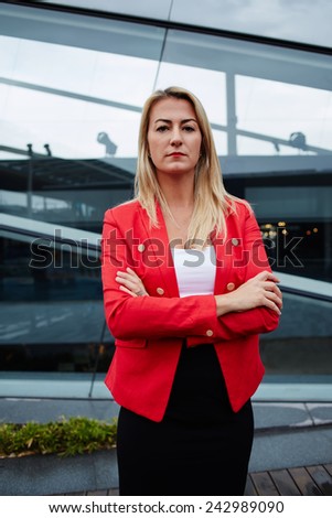 Beautiful woman in business suit looking at you with her arms folded confidently, business woman standing with crossed hand outside the office