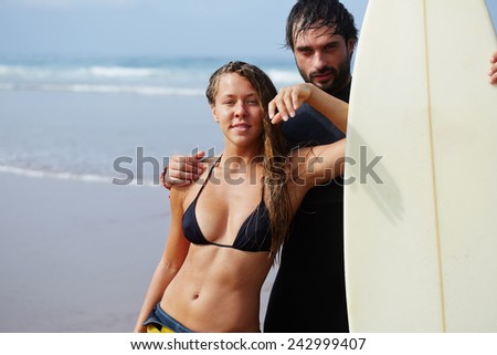 Young woman laughing with her boyfriend before their sunday surf lesson