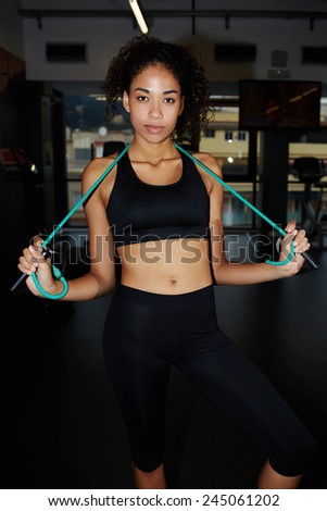 Portrait of young fitness girl posing with fitness expander at health center, attractive sportive girl having a rest after workout at gym