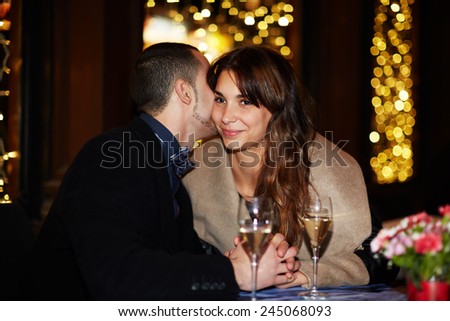 Romantic date at the restaurant, beautiful young couple talking to each other and smiling while spending time at the restaurant together