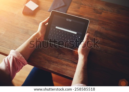 Cropped shot of a man's hands using a digital tablet at cowering office, on line shopping at home, cross process, filtered image, data security, flare light