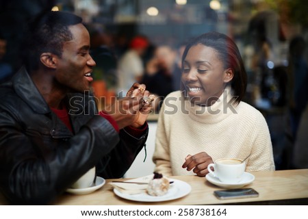 Portrait of young beautiful couple in love having coffee in beautiful cafe, two young people in cafe enjoying the time spending with each other